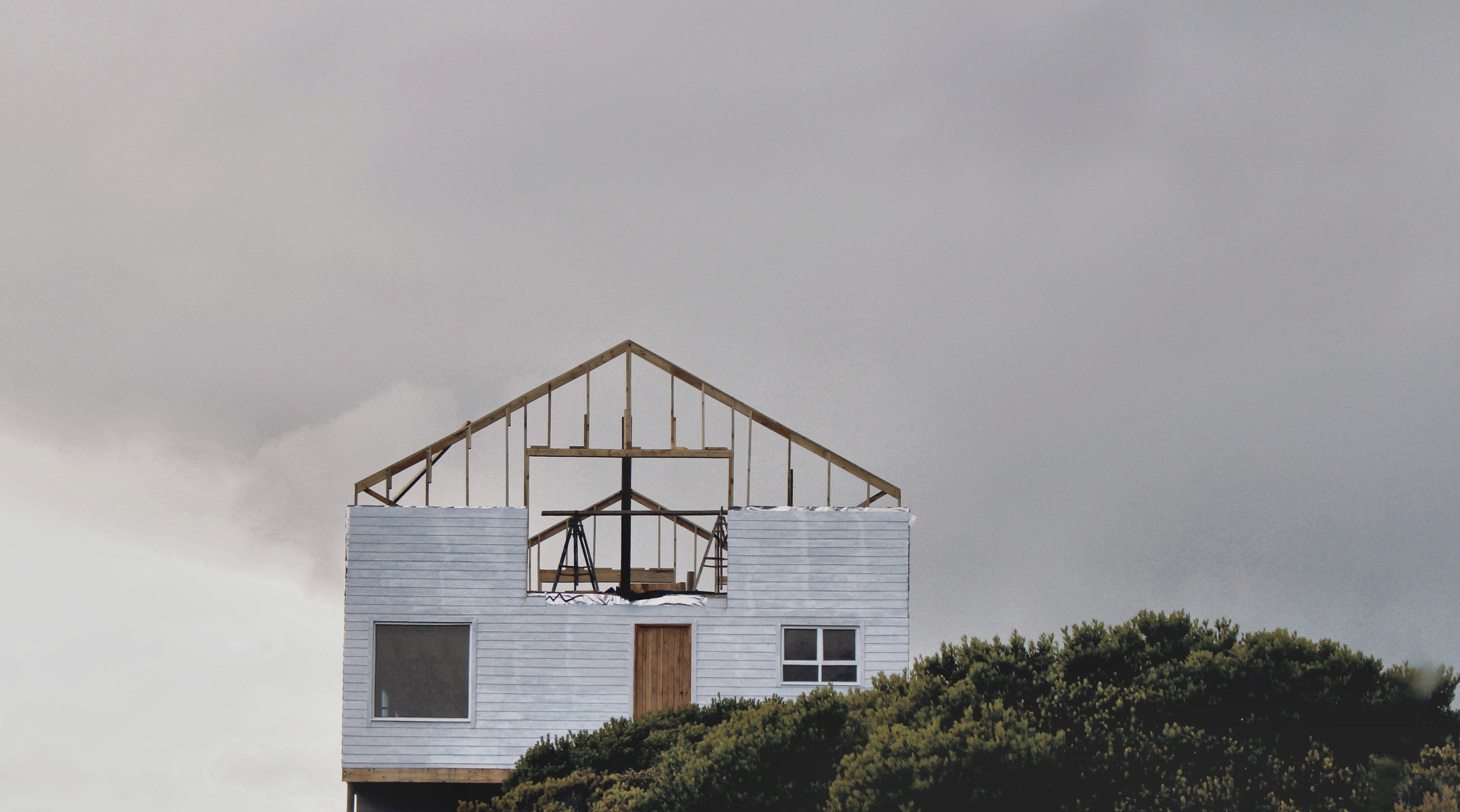 A picture of a house being built where you can see the roof framework.