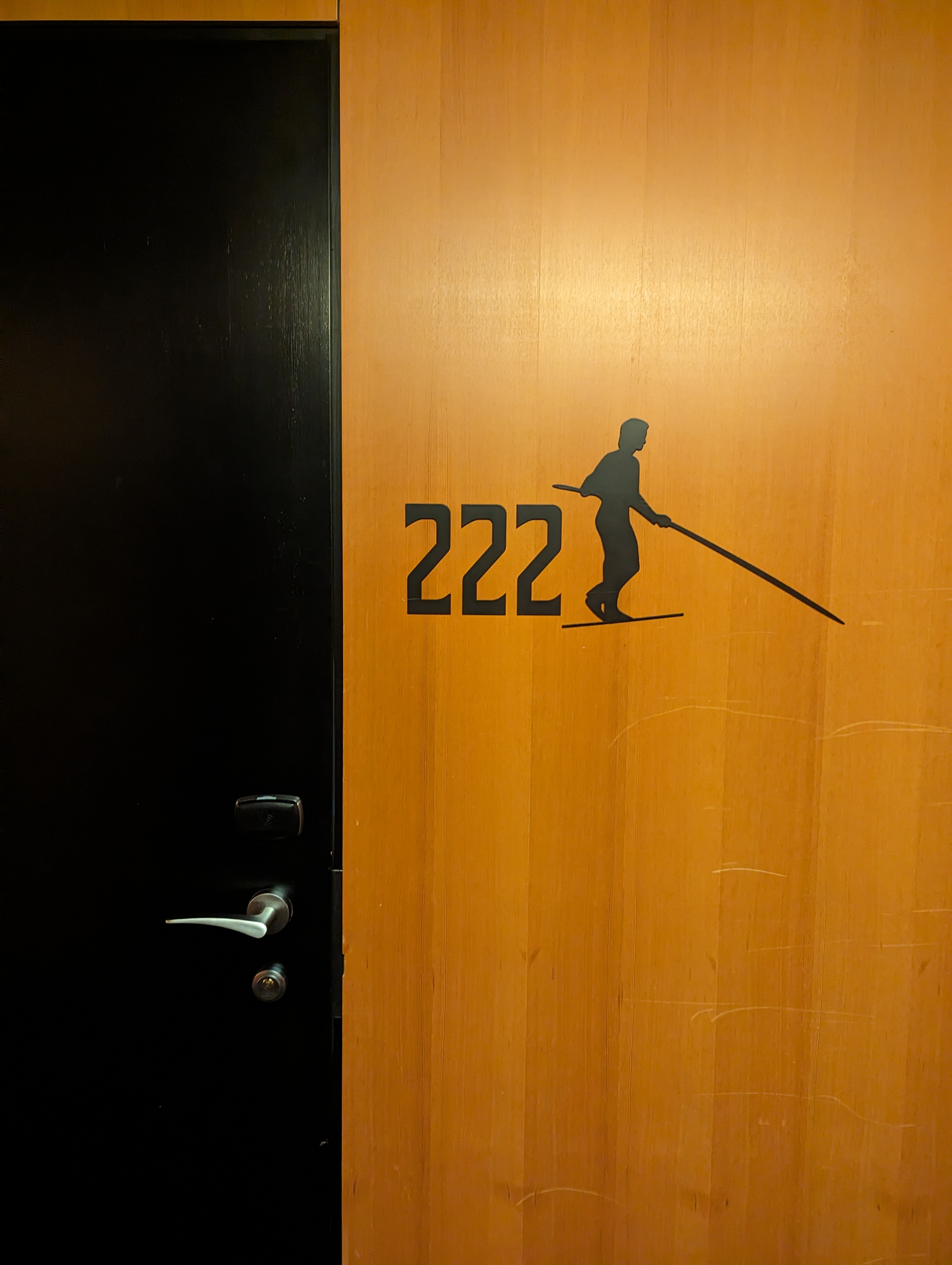 Hotel room door 222 with a tightrope walker